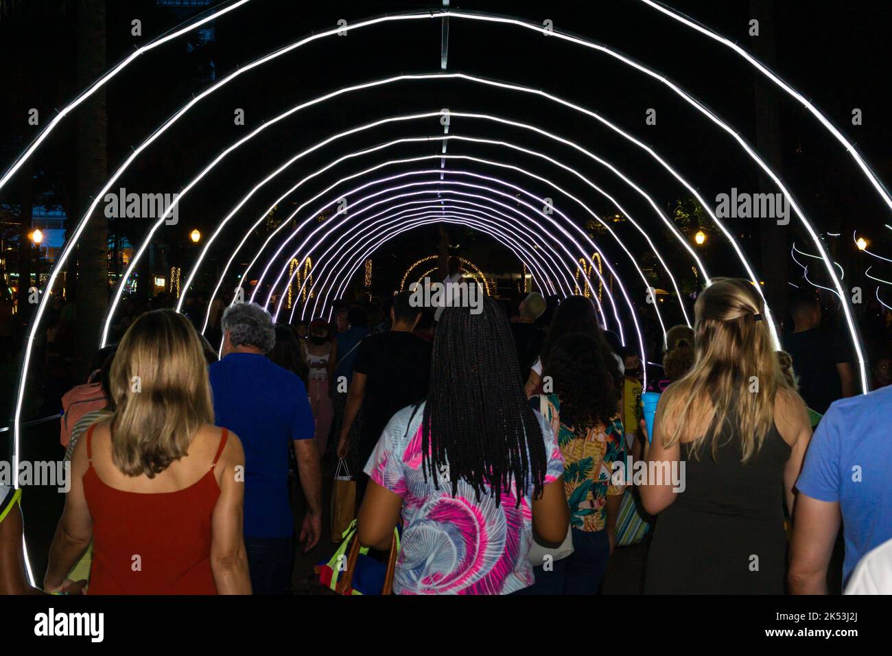 Vista posteriore della gente e passeggiate attraverso un tunnel LED durante il Natale a Praca da Liberdade a Belo Horizonte, Minas Gerais, Brasile. Foto Stock