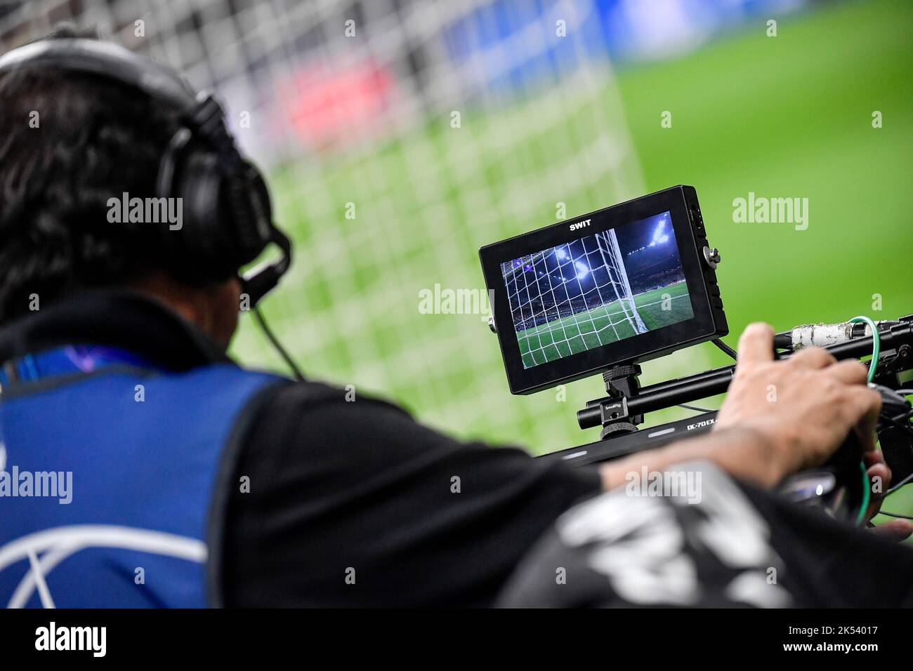Un cameraman guarda sul monitor mentre spara con la telecamera posizionata dietro la porta di calcio durante la partita di calcio del gruppo C della Champions League b Foto Stock