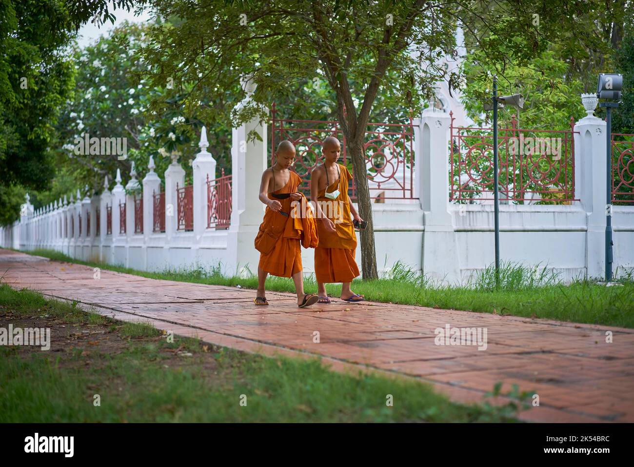 Giovani monaci novizi che camminano e chiacchierano, portati ad Ayutthaya, Thailandia, nel maggio 2022. Foto Stock