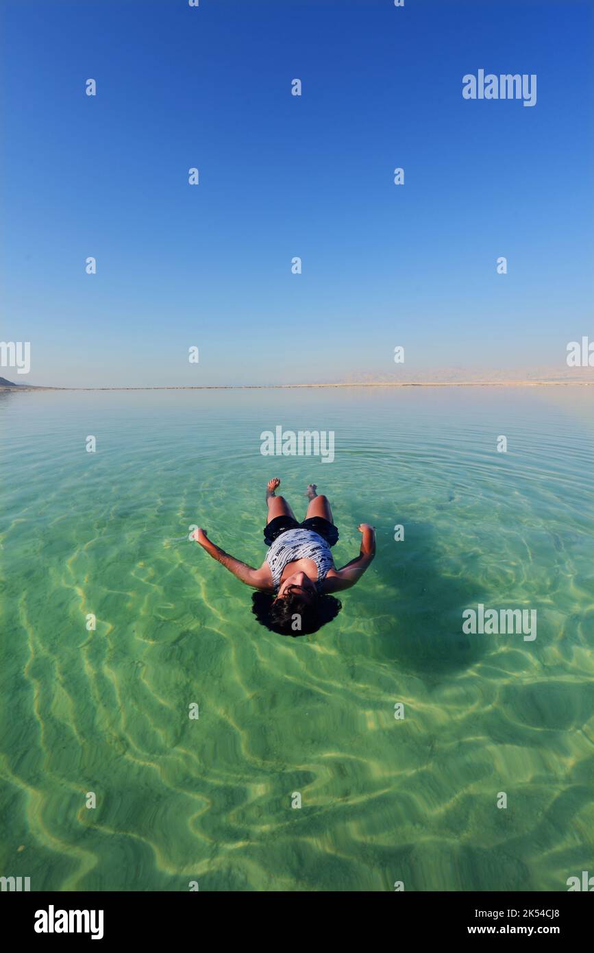 Galleggiando sulle acque salate del Mar Morto in Israele. Foto Stock