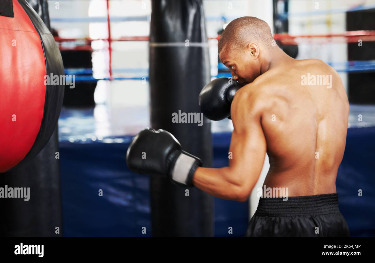 Il boxe è interamente circa la dedica e la determinazione. Pugile afro-americano che pratica con una palla da pugno. Foto Stock