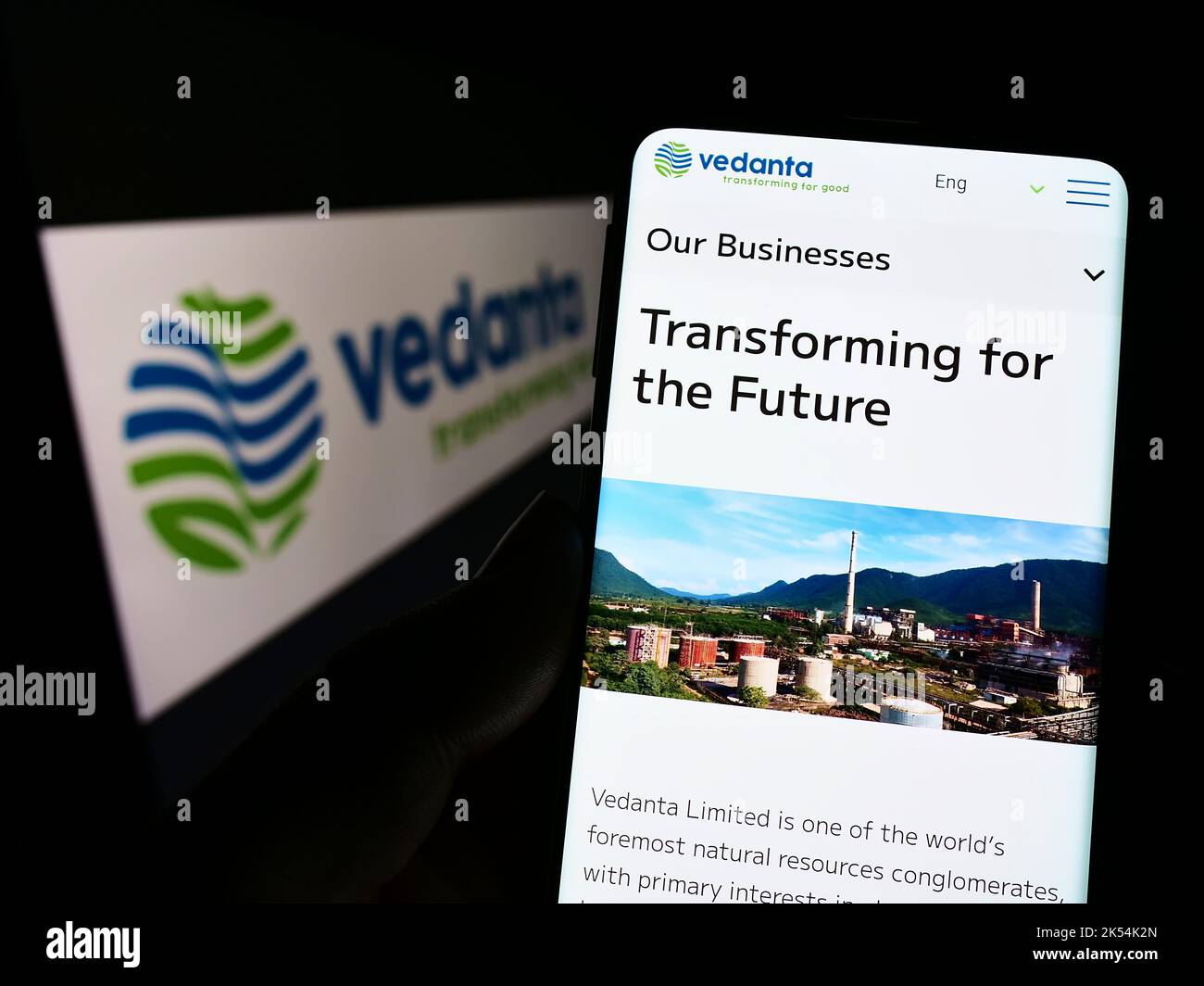 Persona in possesso di smartphone con pagina Web della società mineraria indiana Vedanta Limited sullo schermo di fronte al logo. Messa a fuoco al centro del display del telefono. Foto Stock