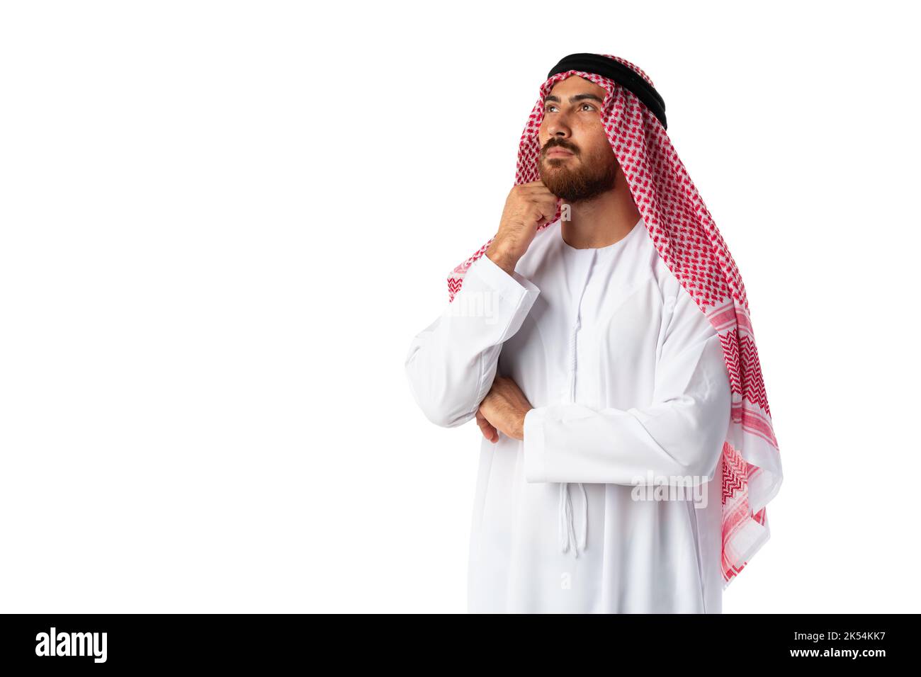 Giovane arabo che indossa abiti tradizionali pensando a qualcosa Foto Stock