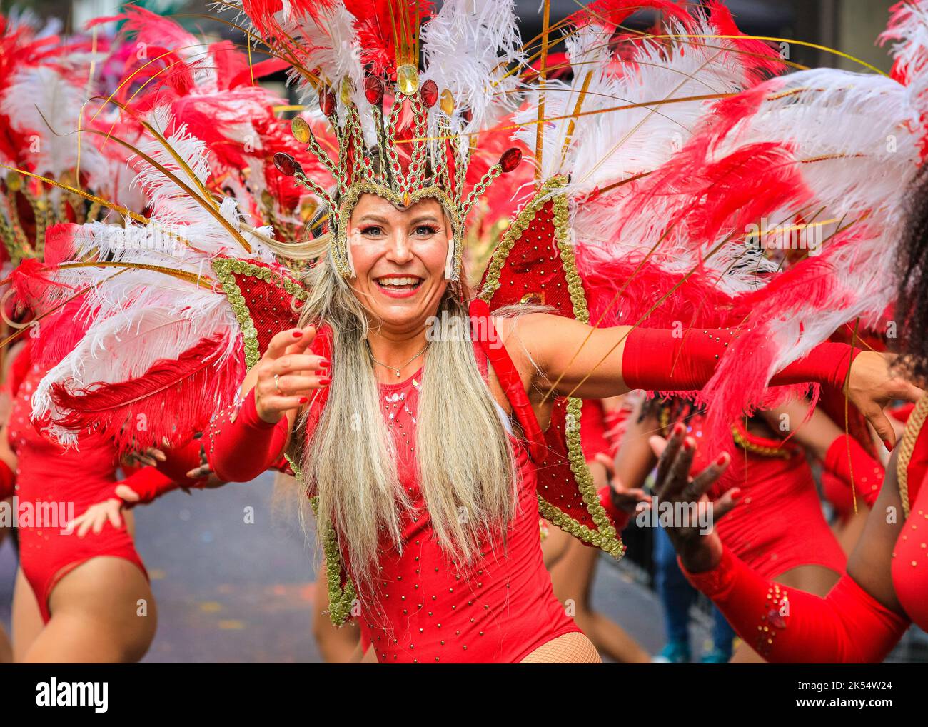 La ballerina Samba sorride in vivace costume rosso con la Paraiso School of Samba, Notting Hill Carnival, Londra, Regno Unito Foto Stock