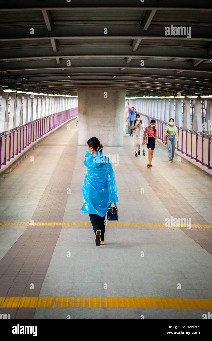 Una giovane signora tailandese fa la sua strada lungo una camminata in cielo verso un treno sopraelevato BTS a Bangkok, Thailandia. Foto Stock
