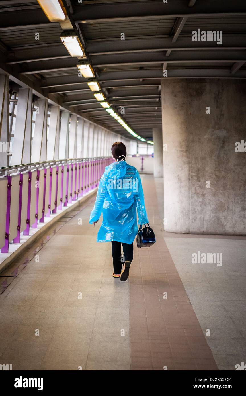 Una giovane signora tailandese fa la sua strada lungo una camminata in cielo verso un treno sopraelevato BTS a Bangkok, Thailandia. Foto Stock