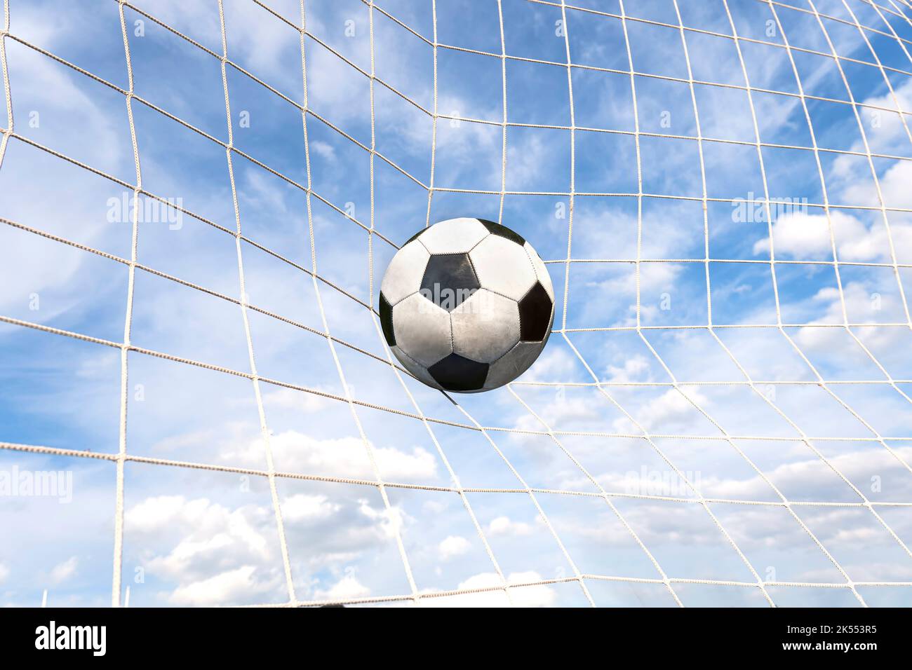 Simbolo del successo e della vittoria. Il calcio classico ha il colore bianco e nero che entra nella rete in gol dopo essere stato tirato nel gioco con una b Foto Stock