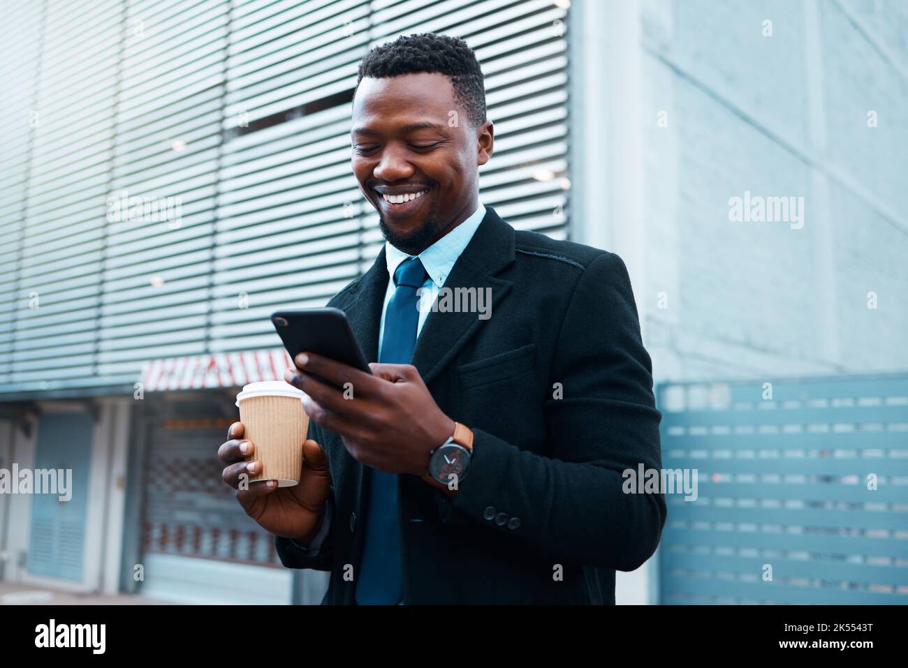Caffè, social media e uomo d'affari al telefono nella città di Singapore con un sorriso al mattino. Chat di lettura felice, aziendale e dei dipendenti africani Foto Stock