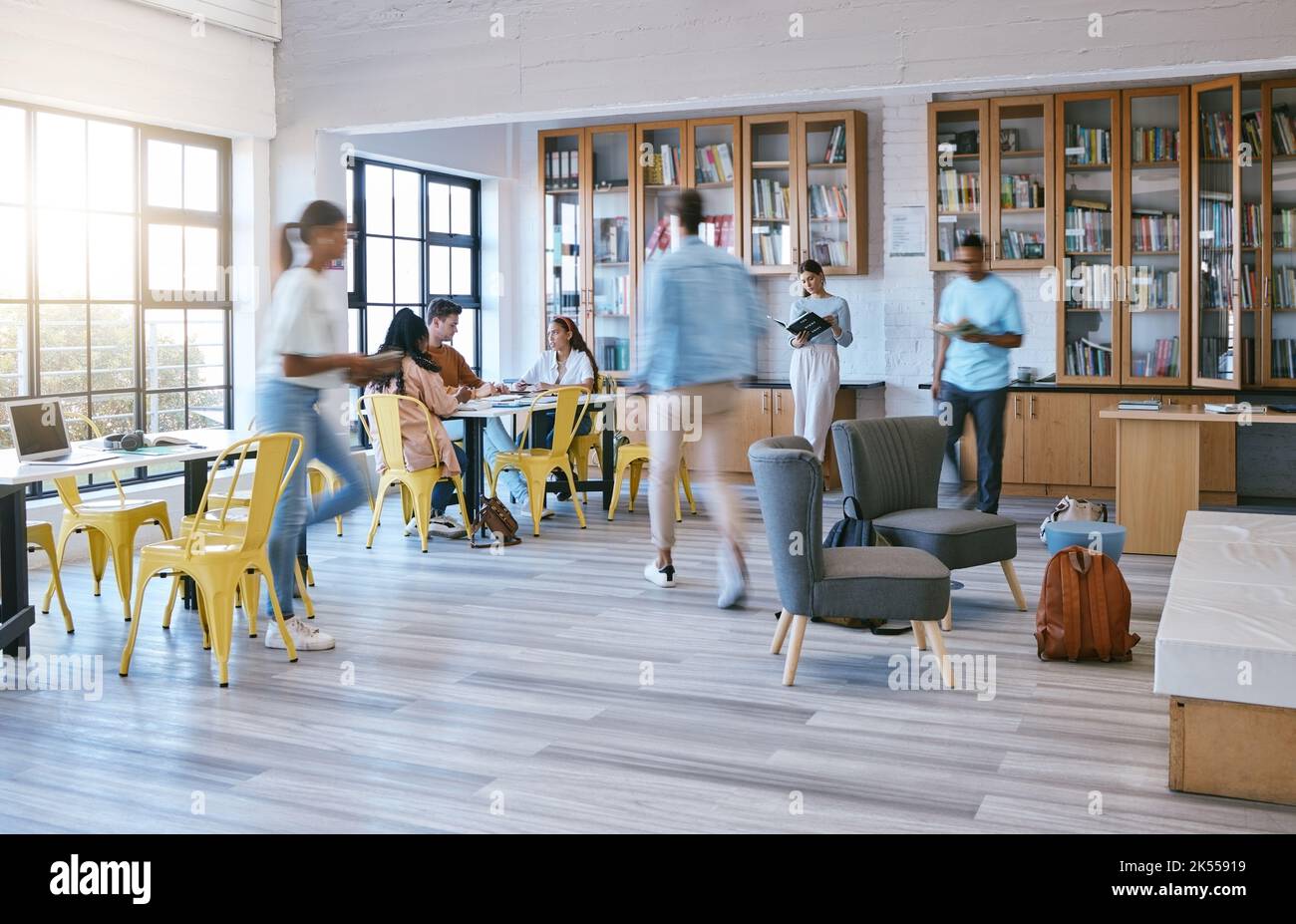 Campus creativo, biblioteca frequentata e studenti che studiano, ricerano o lavorano nello spazio di lavoro della comunità con un tocco di luce mattutino. Persone con scuola di istruzione Foto Stock