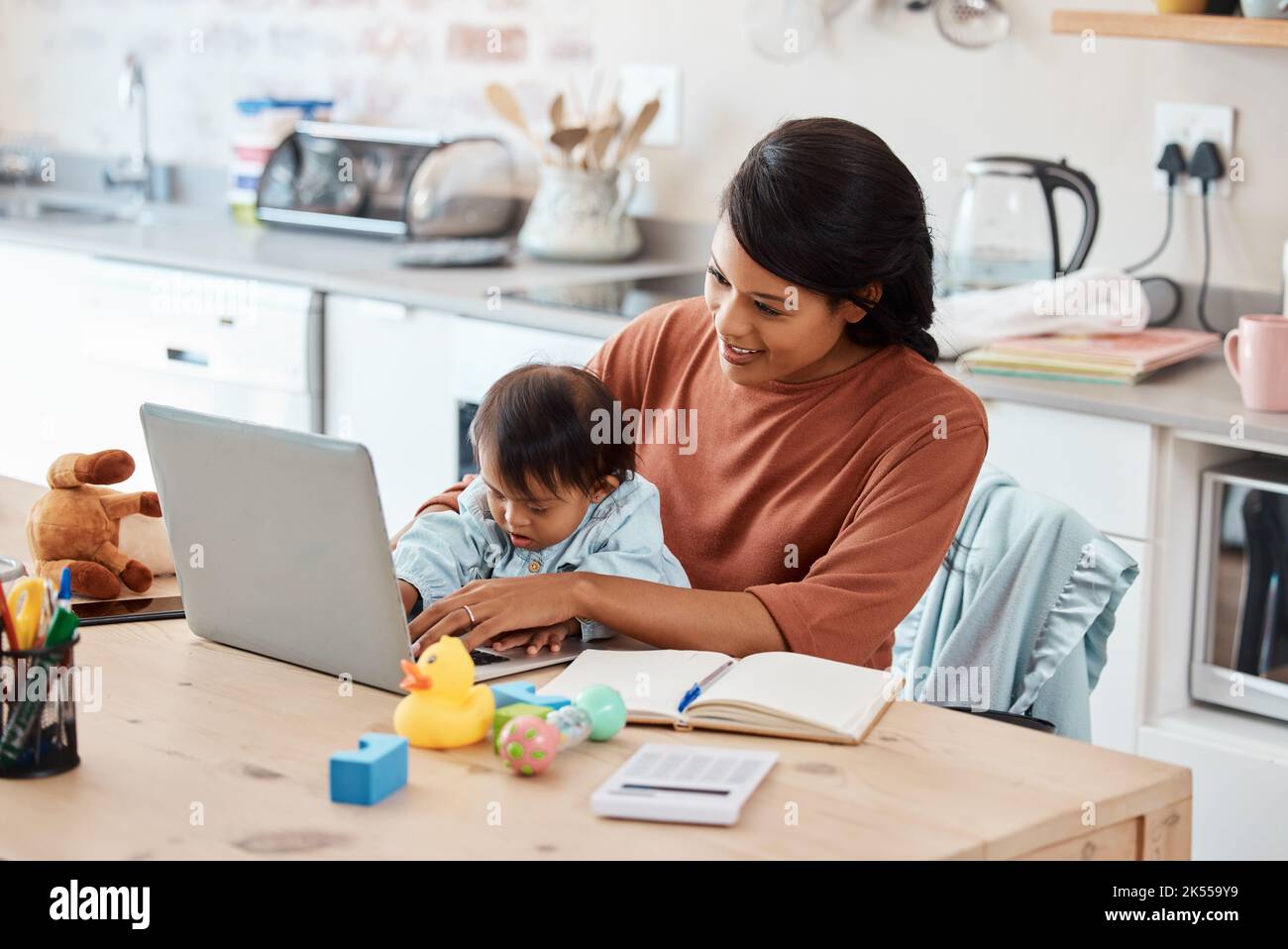 Il bambino, il laptop e la madre lavorano da casa in cucina per finanziario, email o internet. Tecnologia, stile di vita o apprendimento con mamma e bambino in famiglia Foto Stock
