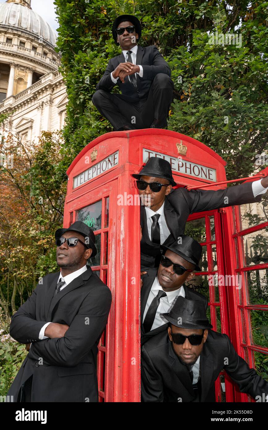 Bilal Musa Huka, Rashid Amini Kulembwa, Seif Mohamed Mlevi, Peter Mnyamosi Obunde e Mohamed Salim Mwakidudu AKA i fratelli del Blues Nero mostrano le loro abilità acrobatiche su e in una scatola telefonica rossa di londra contro la caduta posteriore della Cattedrale di San Paolo. I Black Blues Brothers sono una troupe di acrobati che si sono esibiti per Papa Francesco al Vaticano, alla Famiglia reale britannica e al Royal Variety Show. I Black Blues Brothers sono in tour nel Regno Unito con il loro spettacolo che è un tributo acrobatico al leggendario film di culto. I fratelli Black Blues utilizzarono un'iconica London Red Phone Box per una p Foto Stock