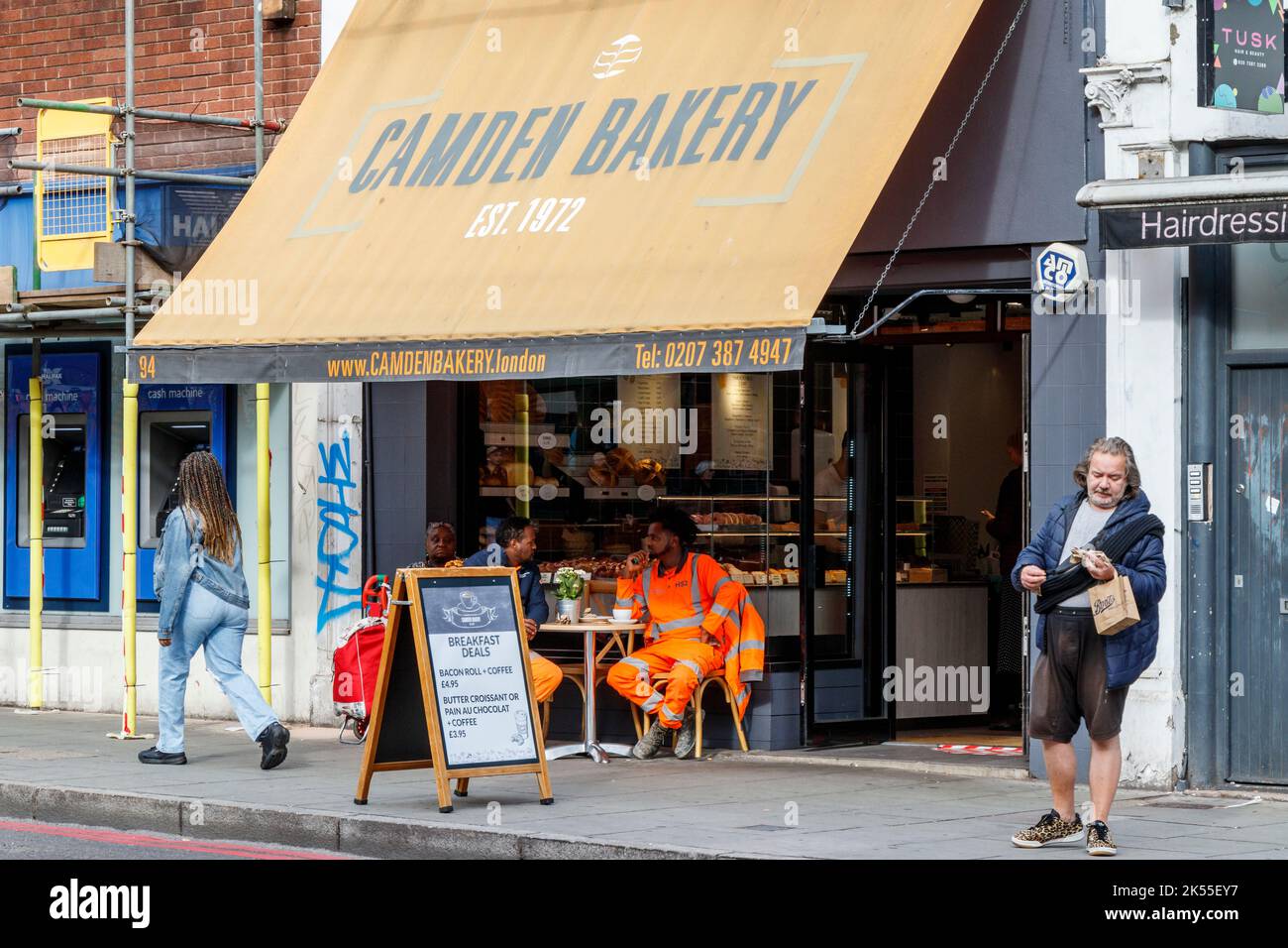 Persone che mangiano sul marciapiede fuori Camden Bakery, un'azienda indipendente a conduzione familiare a Camden Town, Londra, Regno Unito Foto Stock
