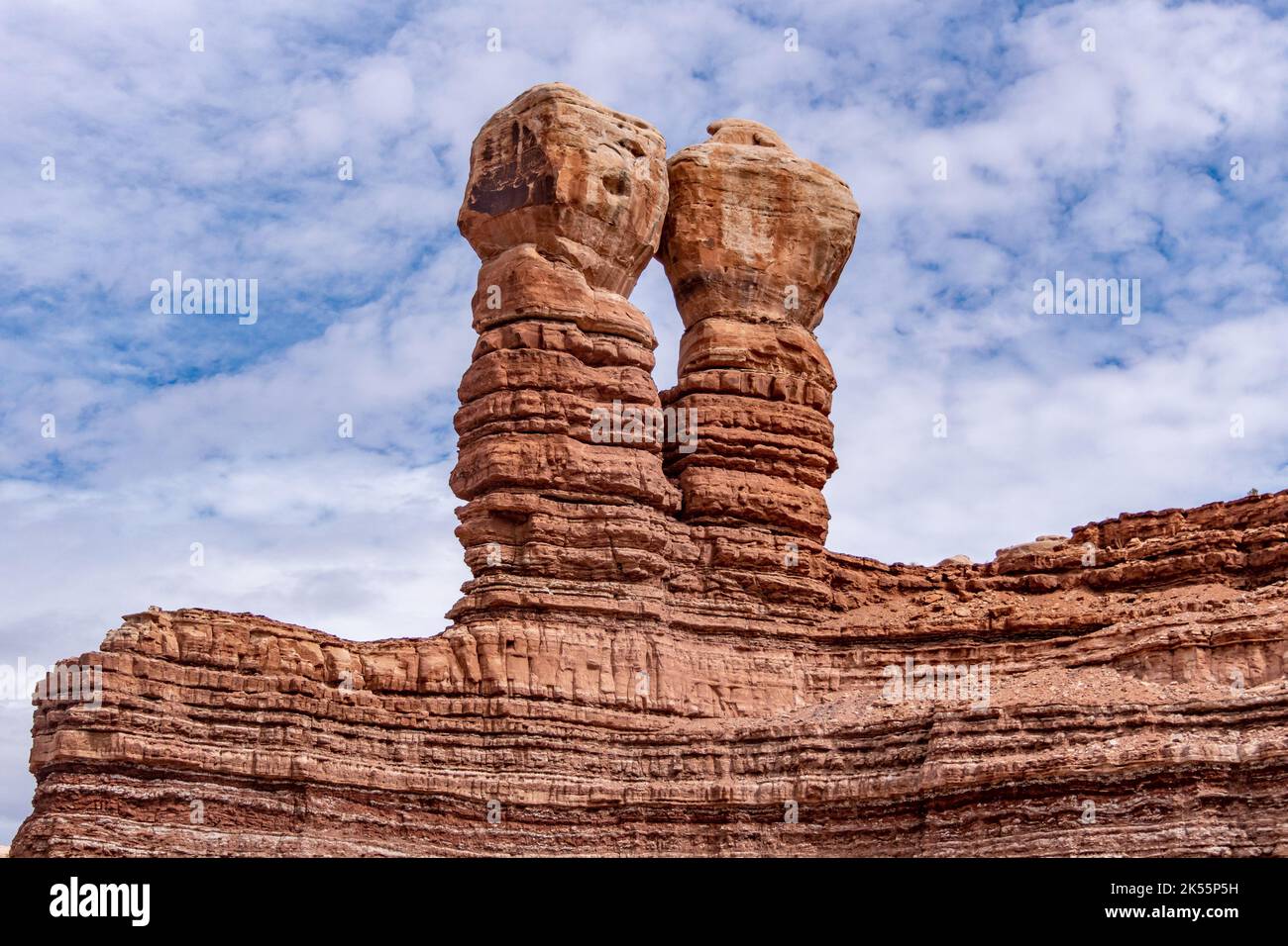 Le formazioni di arenaria dei Navajo Twins su sfondo cielo nuvoloso blu a Bluff, Utah Foto Stock