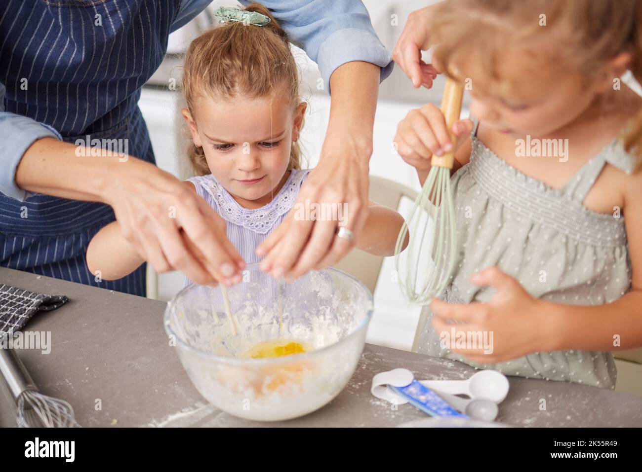 Cucina, ragazze o madre di legame aiutare con le uova per dessert, colazione o dolce ricetta in casa o famiglia cucina casa. Mani, genitori e apprendimento Foto Stock