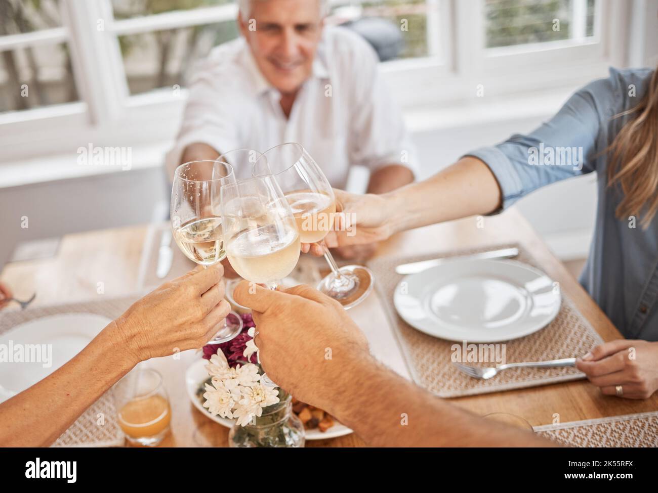 Famiglia, vino e brindisi in celebrazione di una vacanza o buone notizie a tavola, felice e allegro nella loro casa. Rilassati, sorridente ed entusiasta gente Foto Stock