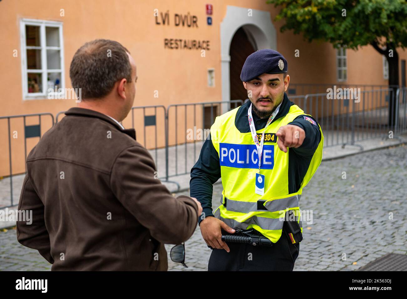 Praga, Repubblica Ceca. 06th Ott 2022. Praga ospita una riunione dei leader non solo dei paesi membri dell'UE, ma anche di altri stati europei. La sicurezza è garantita da centinaia di poliziotti provenienti da Praga e da tutta la Repubblica Ceca, 6 ottobre 2022. Poliziotto e turistico vicino al chiuso Castello di Praga. Credit: David Tanecek/CTK Photo/Alamy Live News Foto Stock