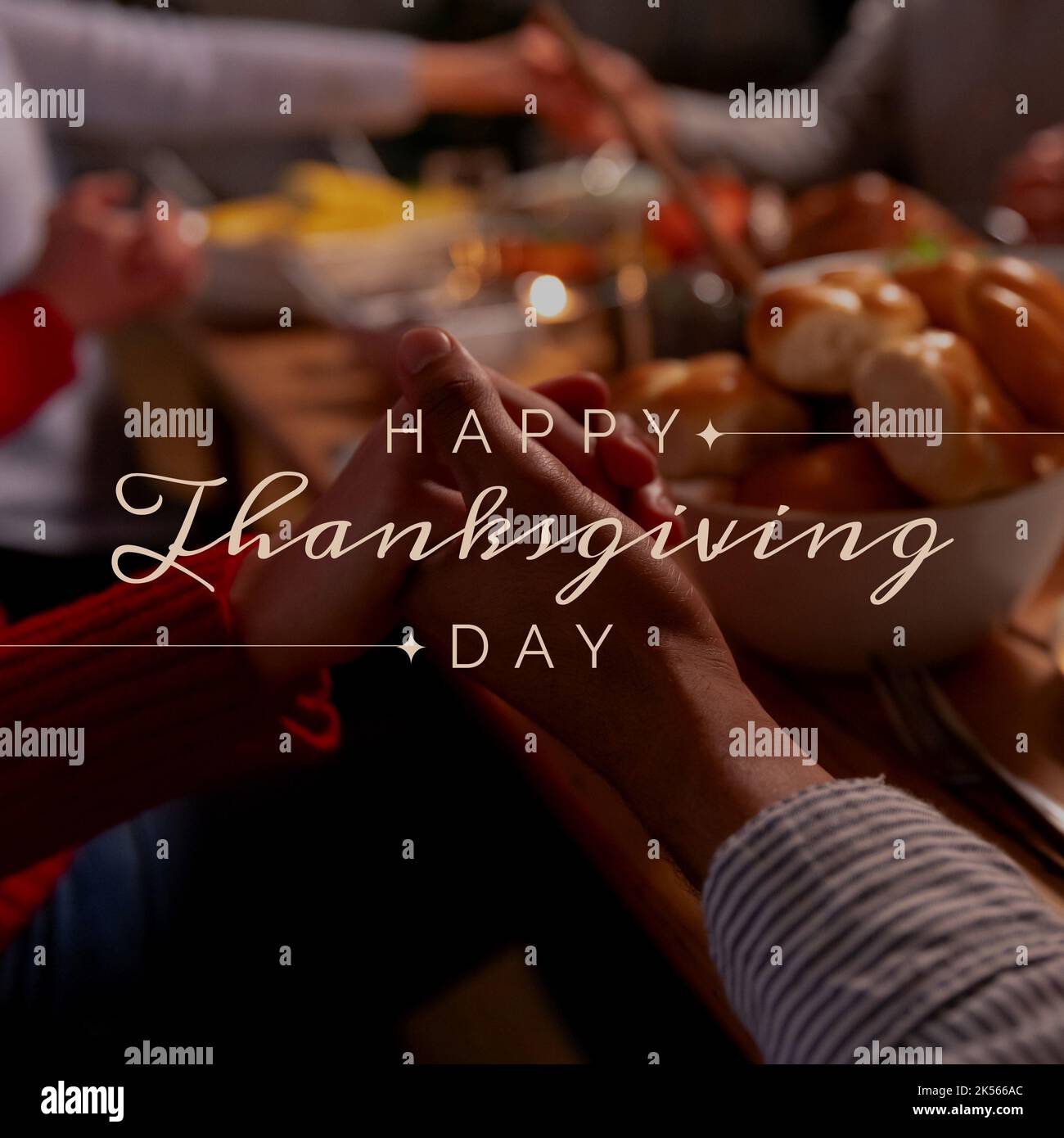 Composizione del testo felice di giorno di ringraziamento sopra le mani di tenuta al tavolo Foto Stock