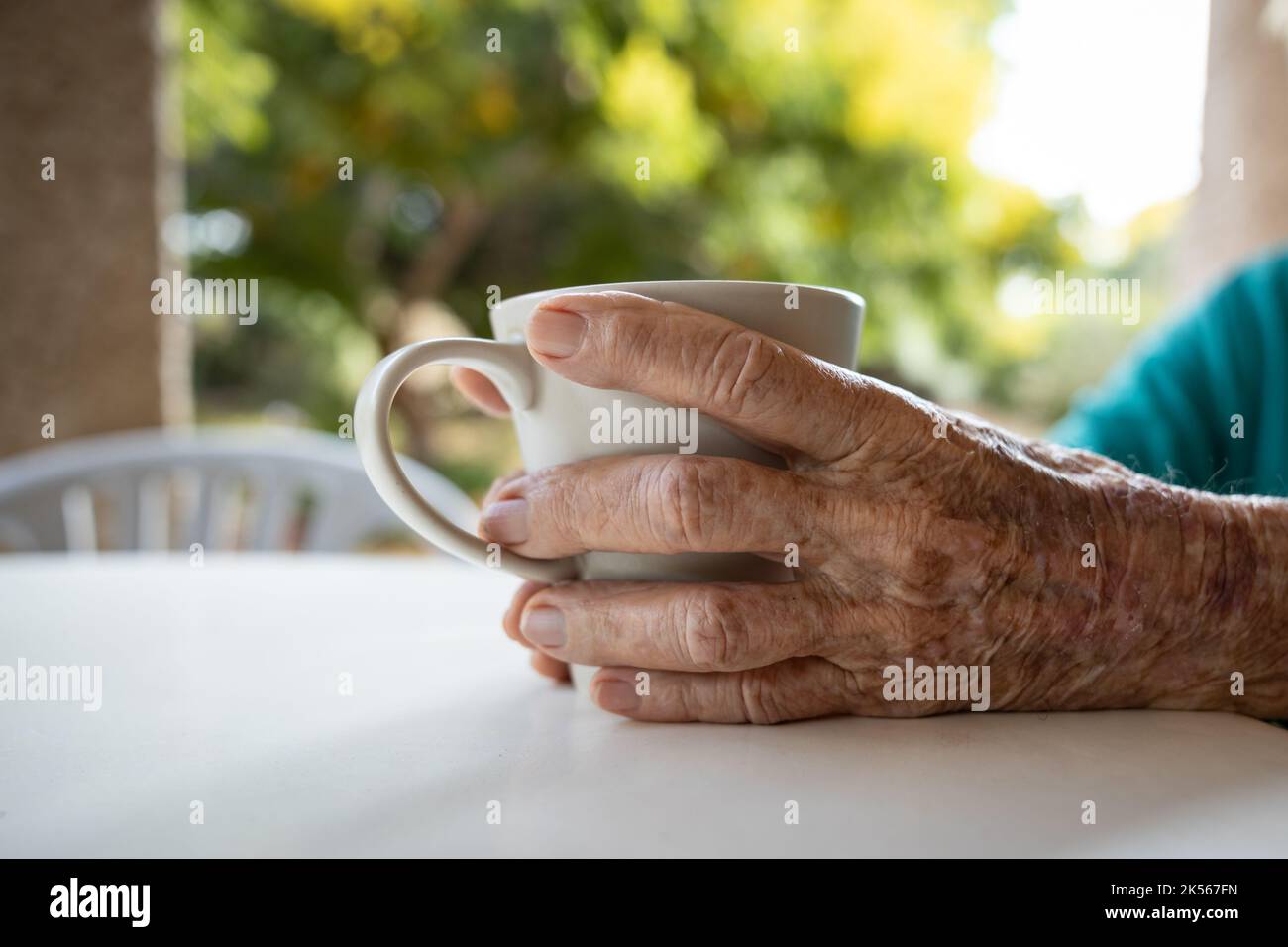 donna anziana che tiene una tazza Foto Stock