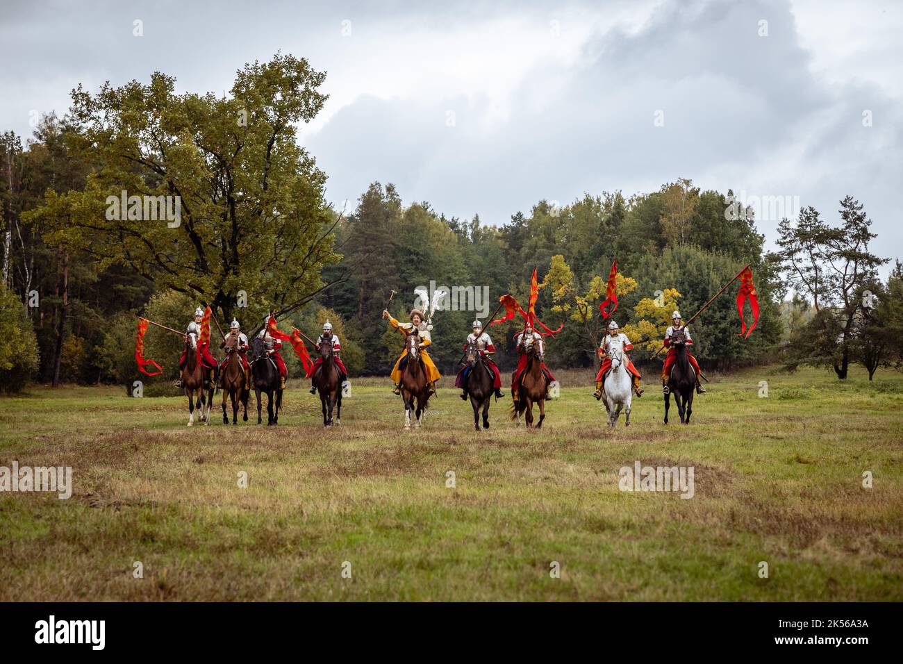 Storia vivente: Uno spettacolo di Horseman in stile Hussar del 17th° secolo. Un gruppo di cavalieri con armi galoppo direttamente verso la macchina fotografica Foto Stock