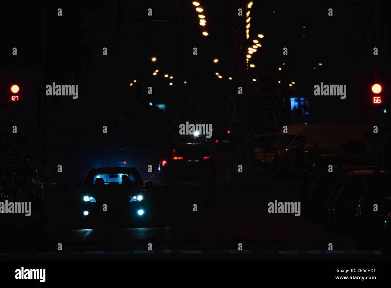 Vista notturna della strada con auto su una strada e luci colorate Foto Stock