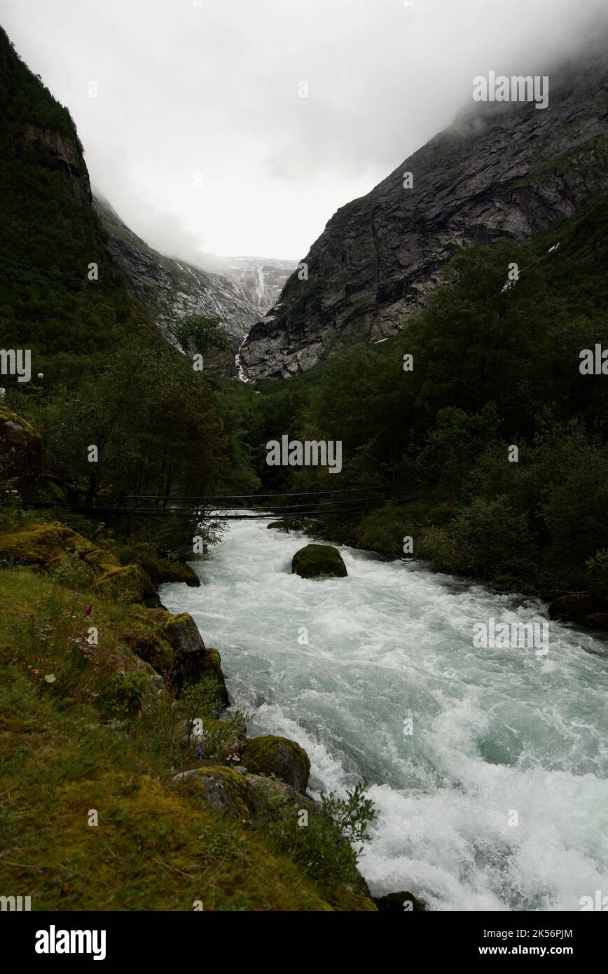 Rapido fiume glaciale che corre lungo una montagna dal ghiacciaio di Briksdal / Jostedal Briksdalsbreen. Nel Parco Nazionale del Ghiacciaio Jostedalsbreen/Jostedal, Norvegia. Foto Stock