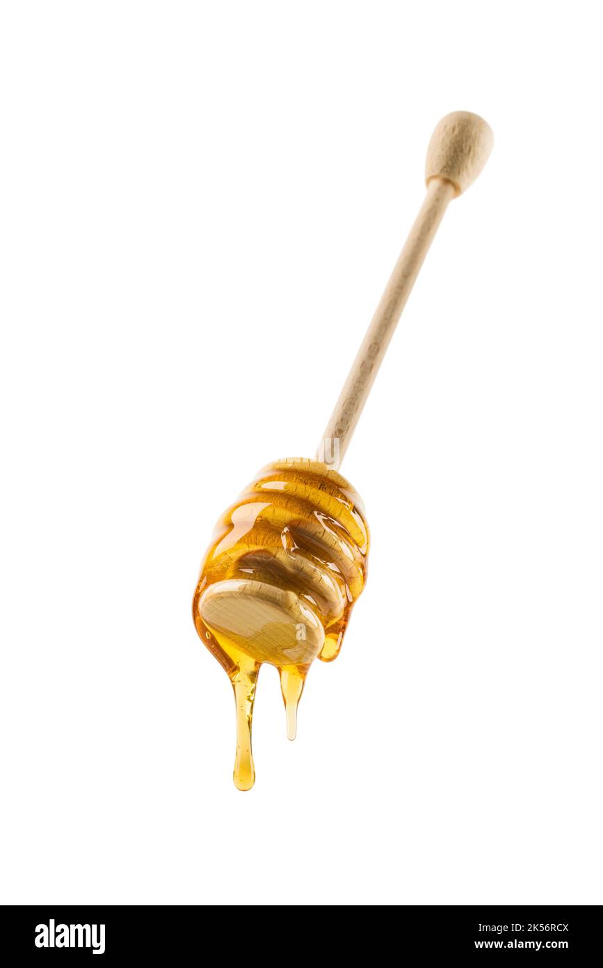 Miele che sgocciola da cucchiaia di legno, isolato su bianco. Foto Stock
