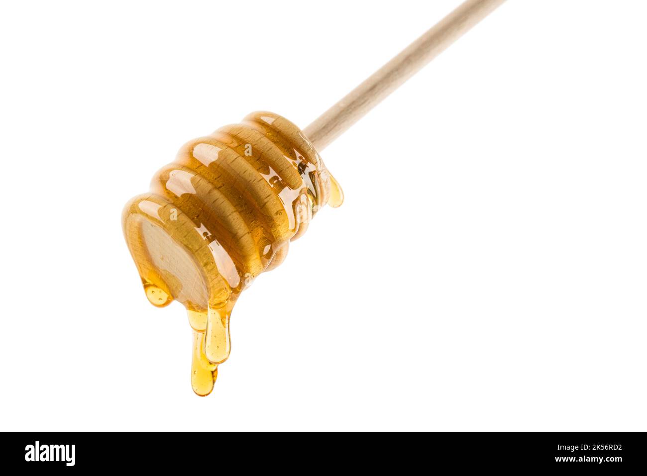 Miele che sgocciola da cucchiaia di legno, isolato su bianco. Foto Stock