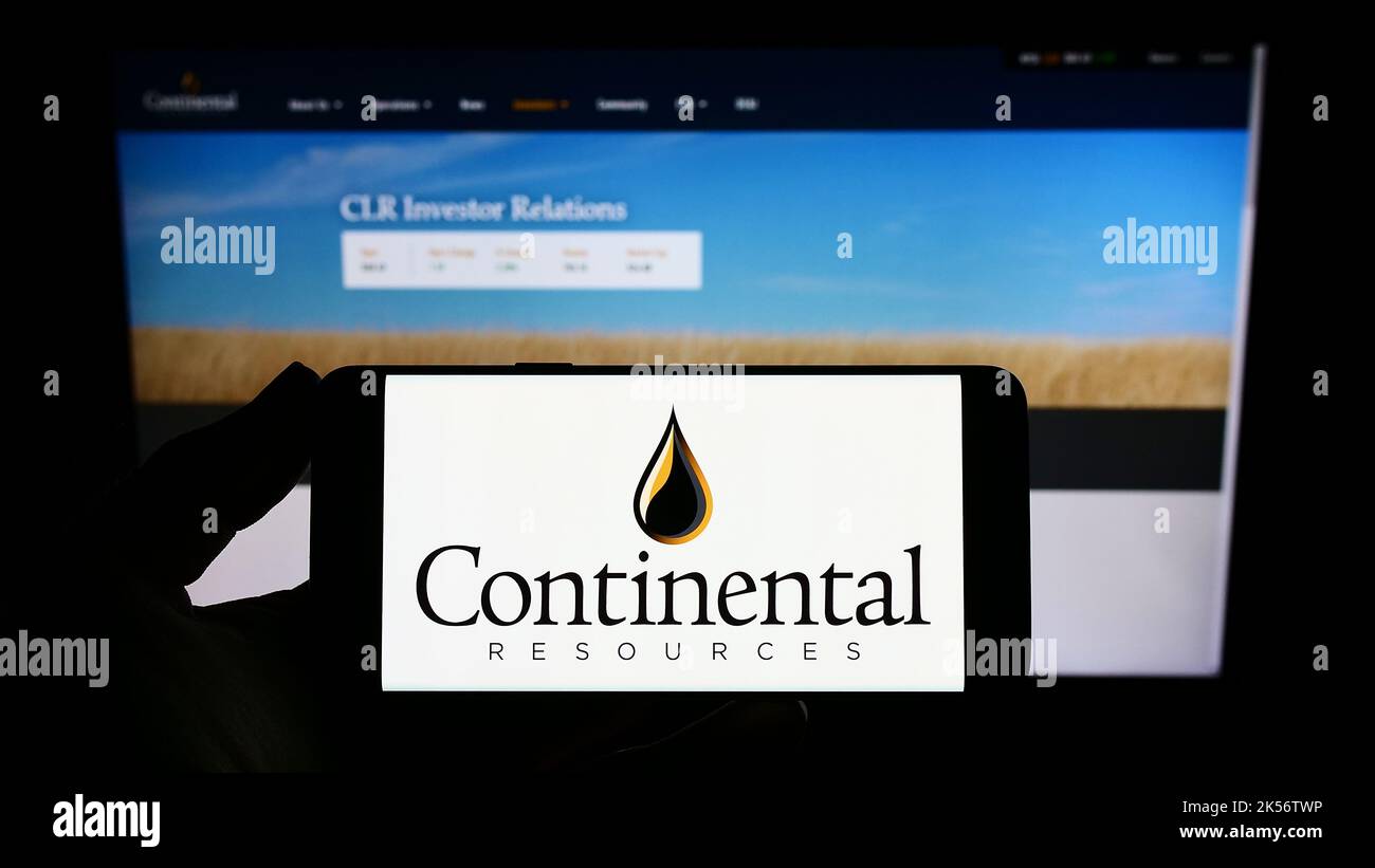 Persona che detiene uno smartphone con il logo della società petrolifera statunitense Continental Resources Inc. Sullo schermo di fronte al sito Web. Messa a fuoco sul display del telefono. Foto Stock