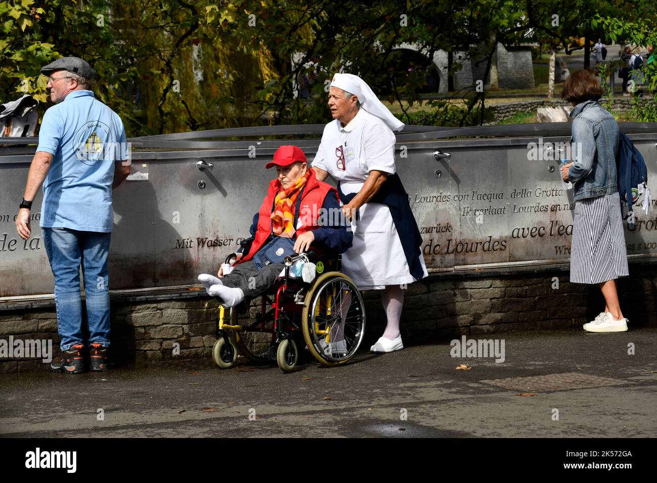 Lourdes, alti Pirenei, Francia. Pellegrini cristiani che raccolgono l'acqua di Lourdes che scorre dalla Grotta di Massabielle nel Santuario di nostra Signora o Foto Stock