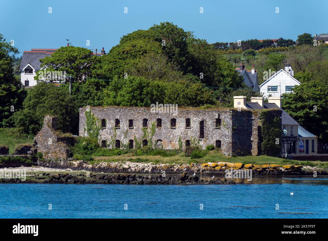 Contea di Cork, Irlanda, 28 maggio 2022. Le rovine di grano di pietra immagazzinano sulla riva della baia di Clonakilty in una giornata di primavera soleggiata. Paesaggio irlandese. Le rovine di Foto Stock