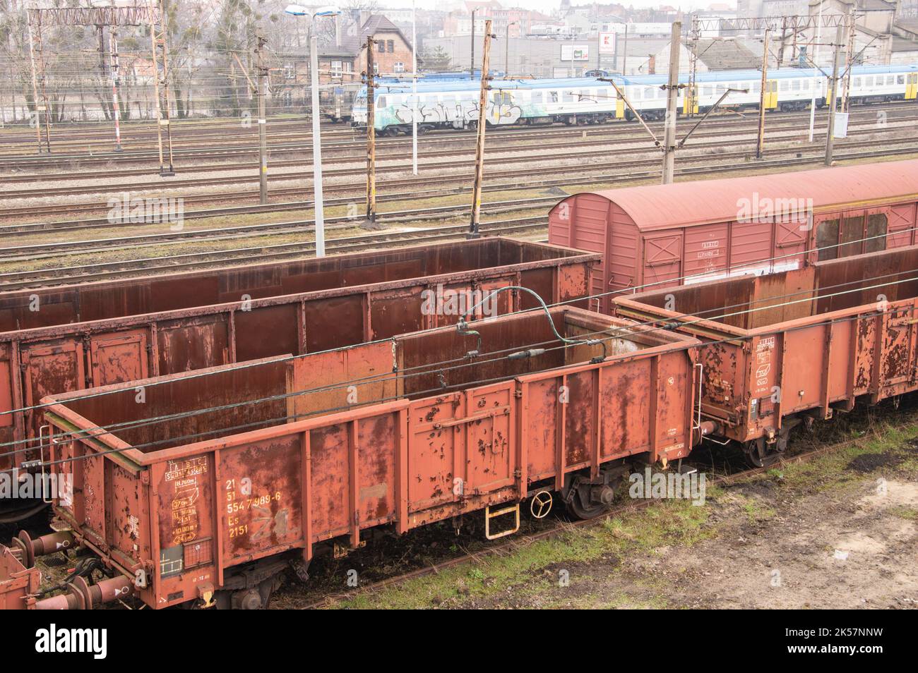 Carrozze ferroviarie, infrastrutture ferroviarie, binari, rotaie e cavi di alimentazione sui binari. Foto Stock