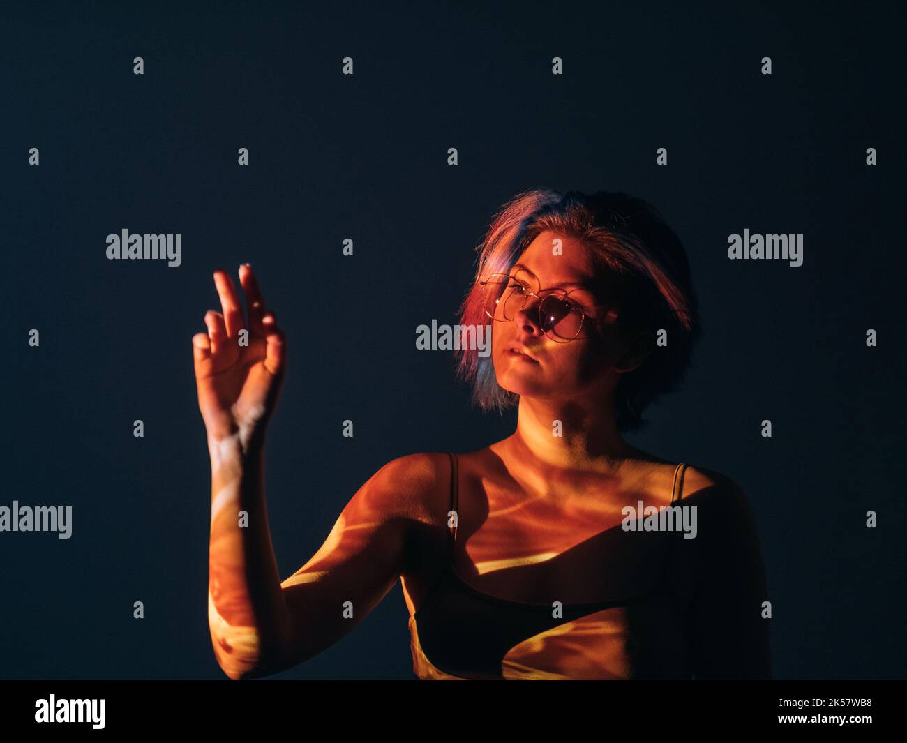 illuminazione spirituale curiosa donna in luce rossa Foto Stock