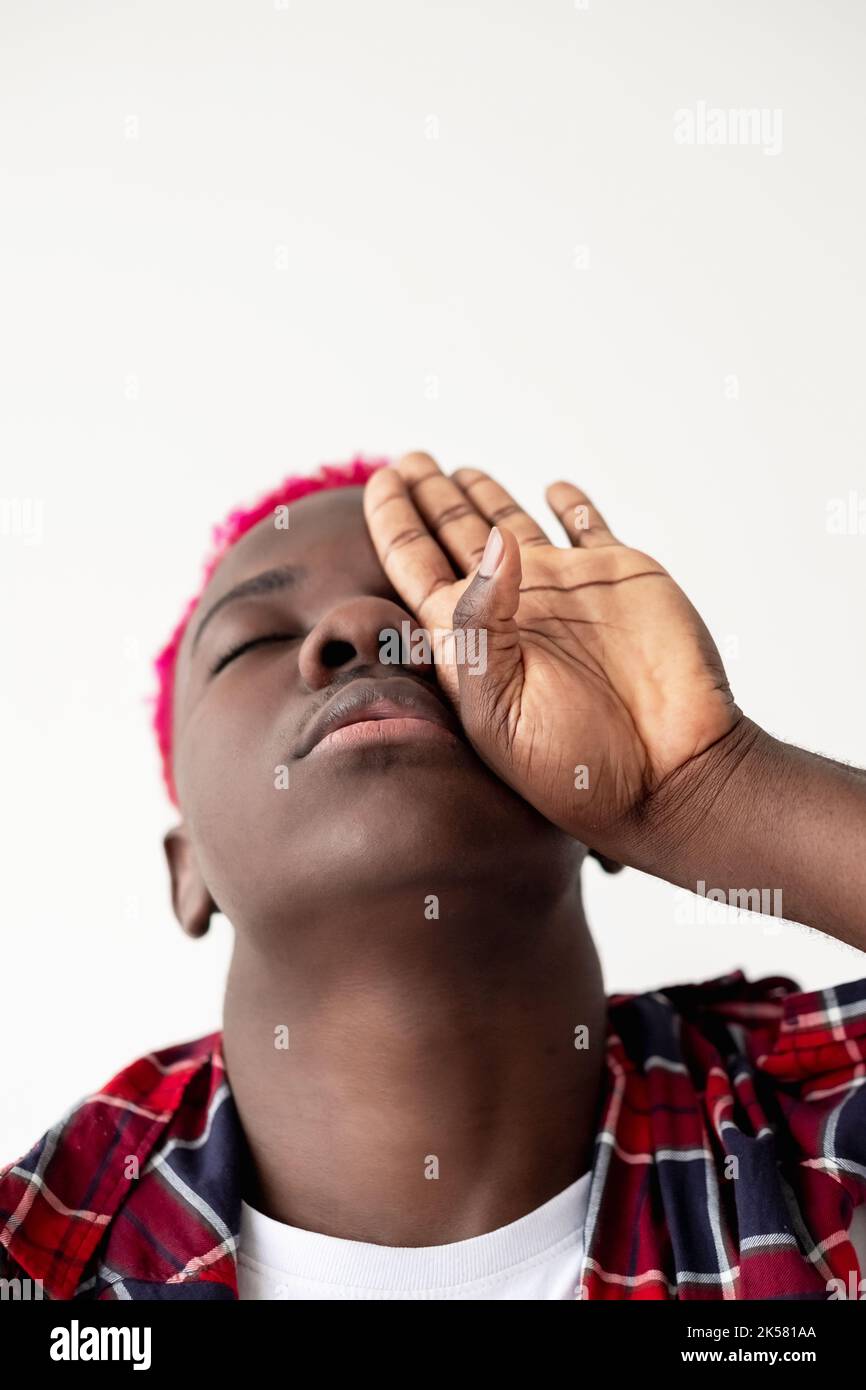 Uomo nero hipster. Ritratto concettuale. Perdita di mente. Pressione sociale. Sensazione di profondità. Calmo ragazzo africano cieco con capelli rosa brillante camicia a scacchi clos Foto Stock