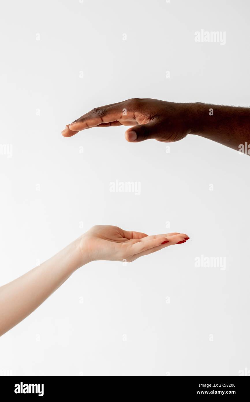 Tolleranza razziale. Scambio di condivisione. Partenariato nazionale. Collaborazione multietnica. Ritratto d'arte concettuale. Lancette bianche femmina e nere maschio holdin Foto Stock