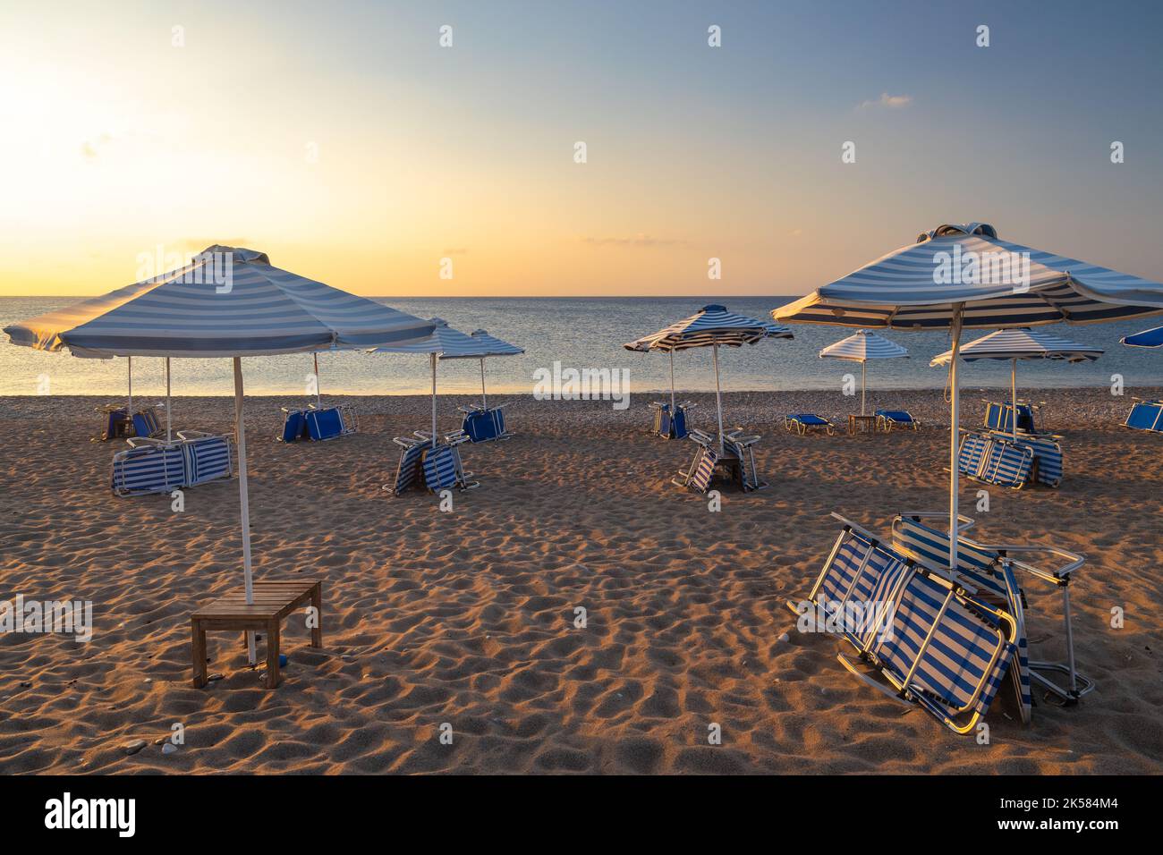 Spiaggia di mare di Afandou con ombrelloni a Rodi all'alba di sole giornate estive, Grecia, Europa. Foto Stock