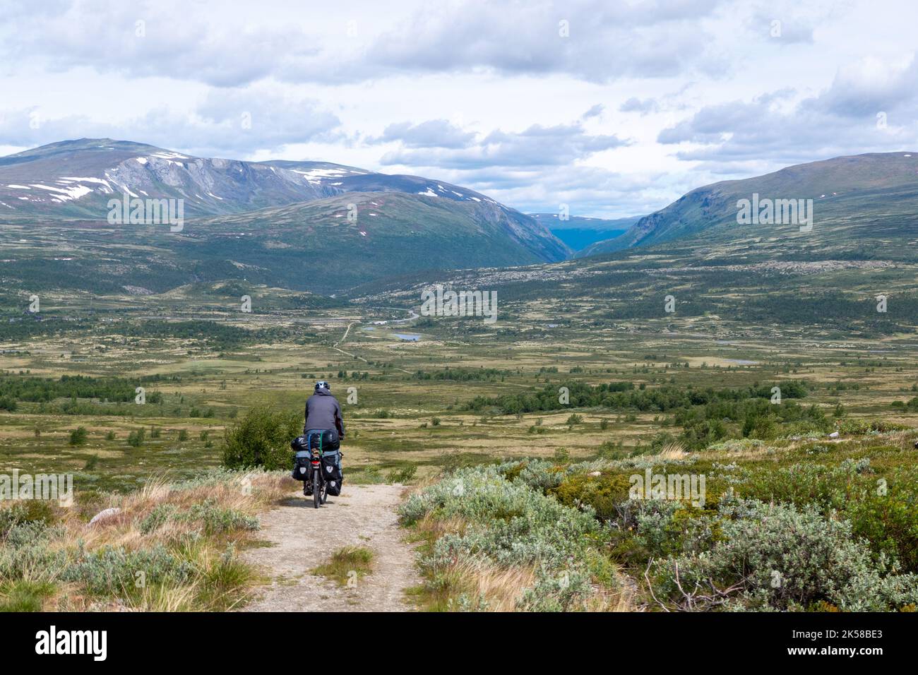 Ciclista su strada sterrata nel bellissimo Parco Nazionale di Rondane, Norvegia Foto Stock