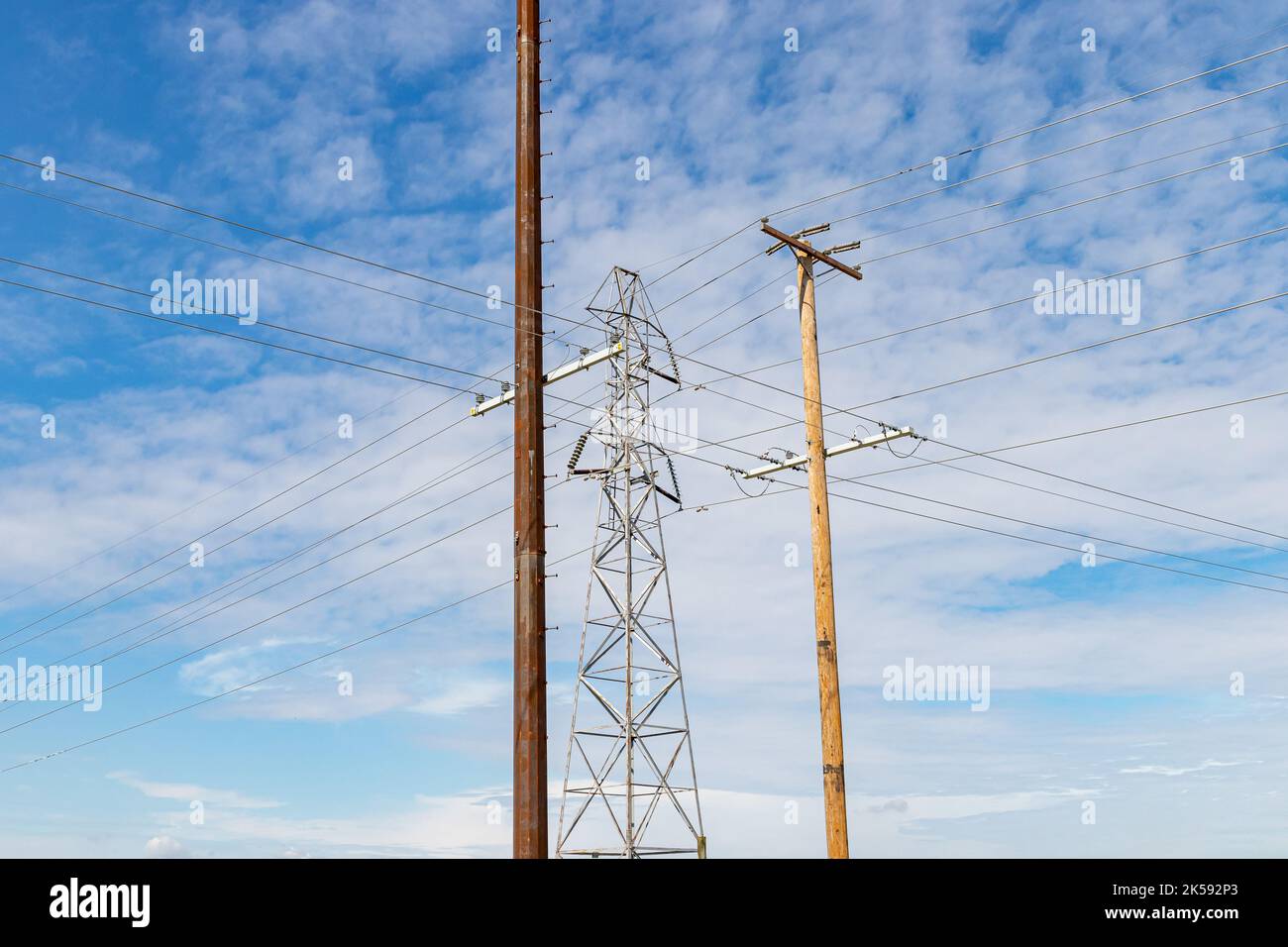 Torre di trasmissione dell'elettricità, pali di energia elettrica in legno e acciaio. Concetto di rete elettrica, infrastruttura e distribuzione. Foto Stock