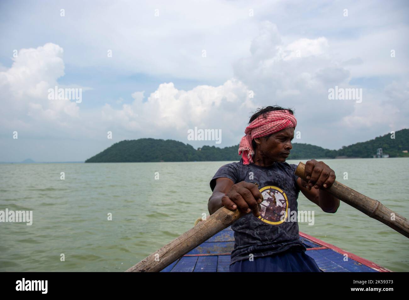 un povero uomo tribale che tira la barca con la mano con la pagaia Foto Stock