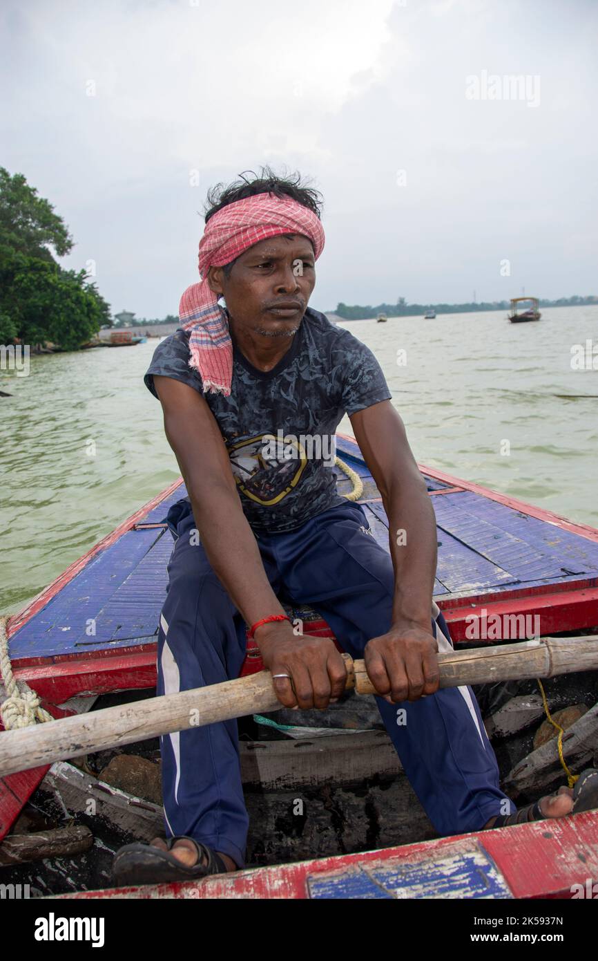 un povero uomo tribale che tira la barca con la mano con la pagaia Foto Stock