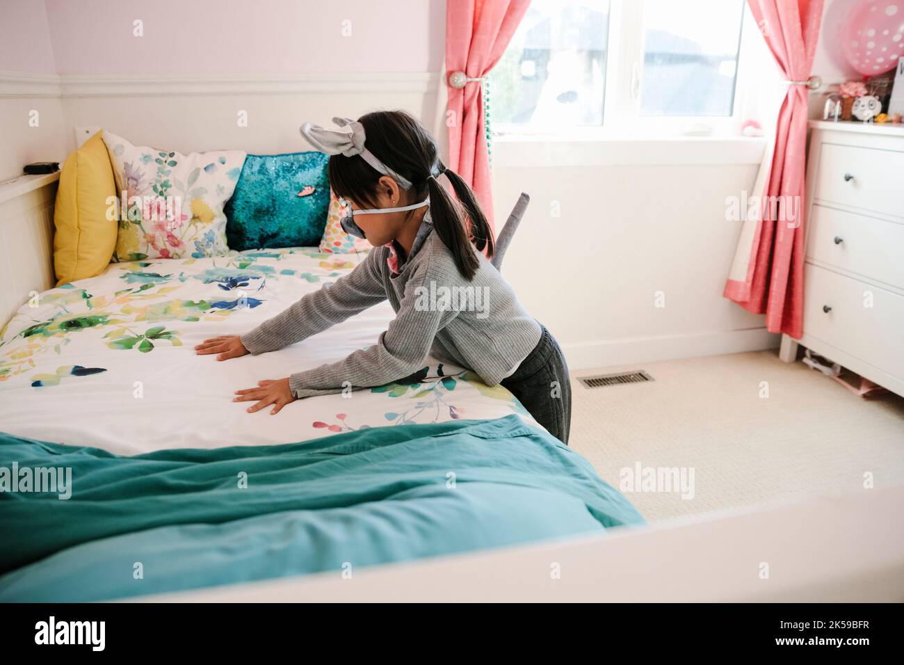 Ragazza riordinare la sua camera da letto Foto Stock