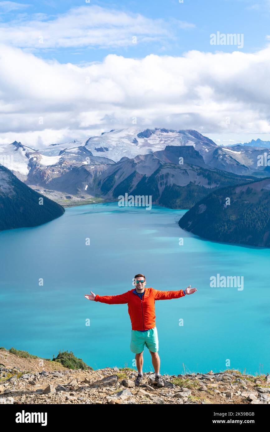 Un uomo si stanca largo per celebrare il summito Panorama Ridge nel Parco Provinciale Garibaldi e godere della vista sulle montagne. Foto Stock