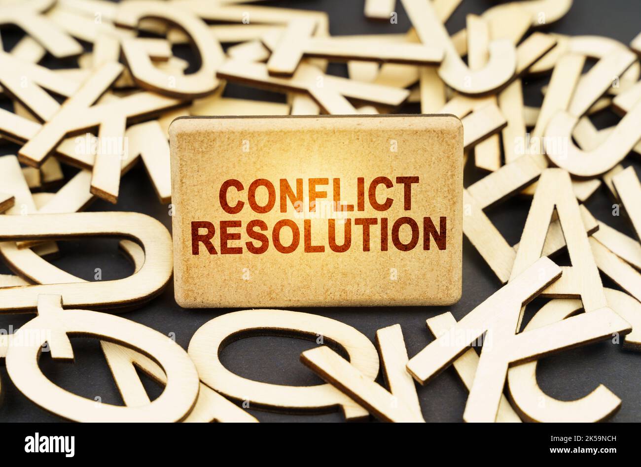 Concetto di istruzione. Tra le lettere di legno c'è un segno con l'iscrizione - Conflict Resolution Foto Stock