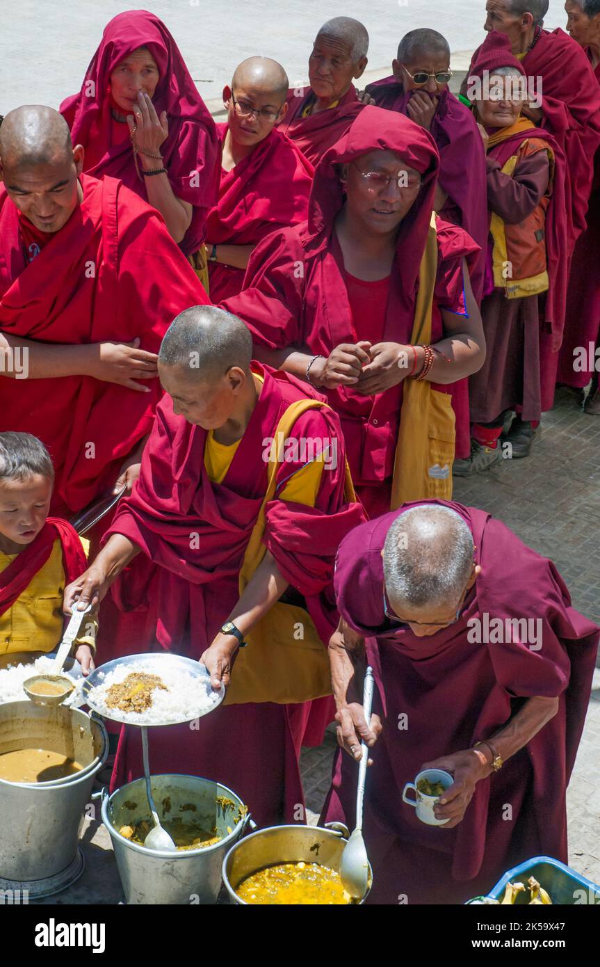 I monaci buddisti ricevono cibo durante i festeggiamenti accogliendo il loro leader spirituale, il Dalai lama in esilio del Tibet, in una visita del 2012 a Ladakh, in India Foto Stock