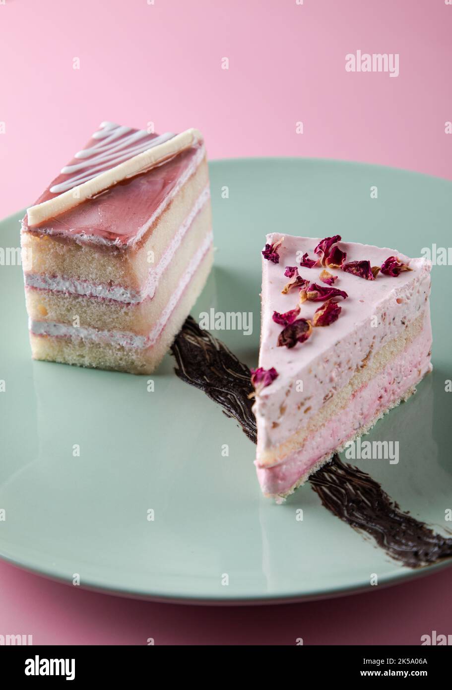 PRELIBATEZZE ROSA: Torta di mousse di rosa con placcatura estetica e torta di mirtilli in un piatto di ceramica verde menta Foto Stock