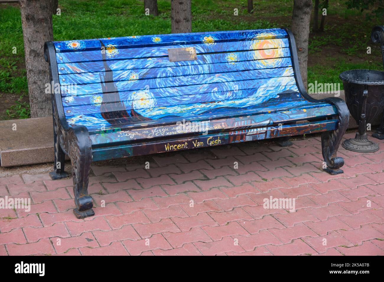 Una classica panca in legno e metallo con un dipinto che ricrea il famoso capolavoro di Vincent Van Gogh, Starry Night. Ad Astana, Nursultano, Kazako Foto Stock