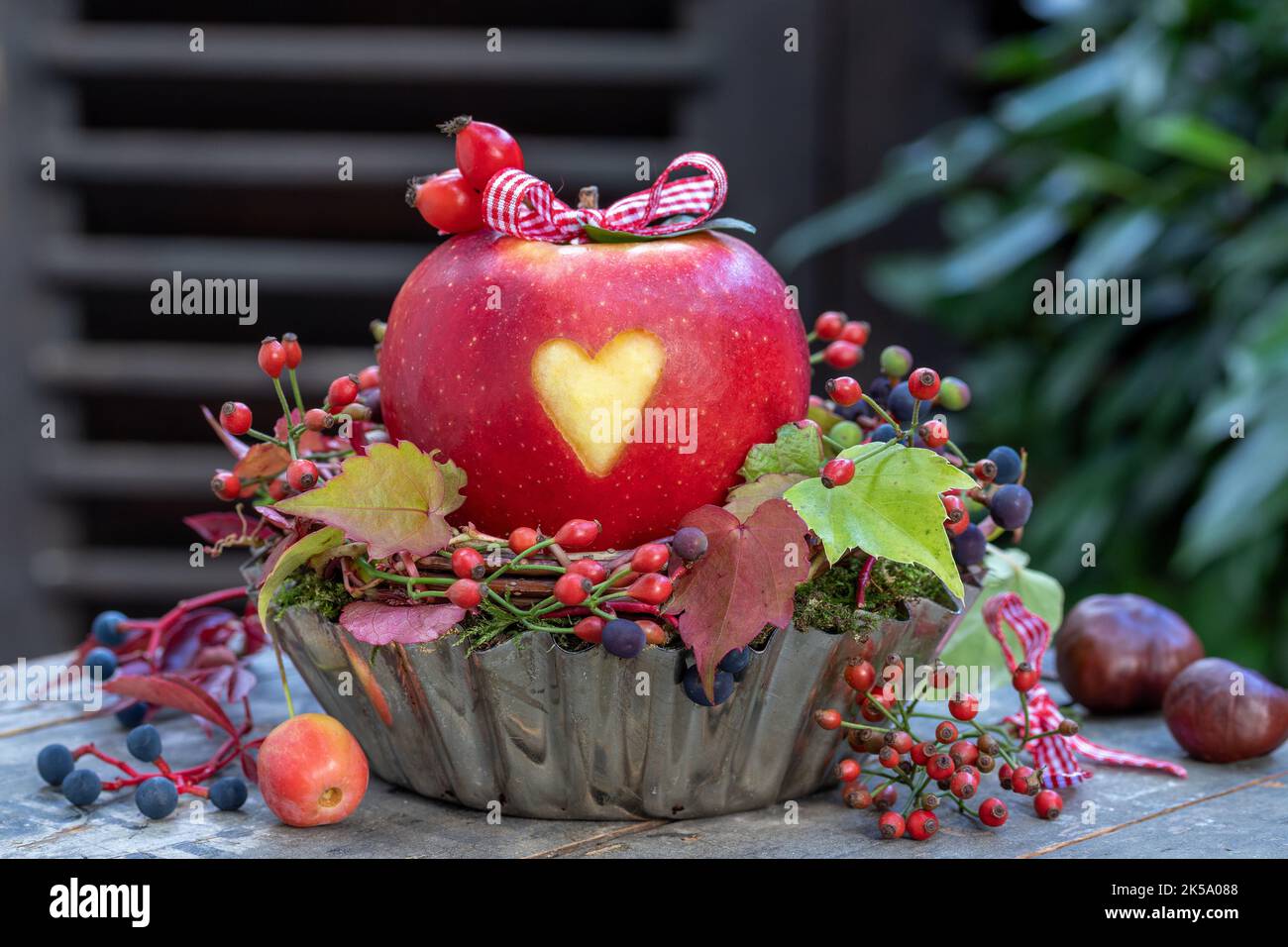 mela con cuore ornamento in vecchia teglia da forno come decorazione autunnale Foto Stock