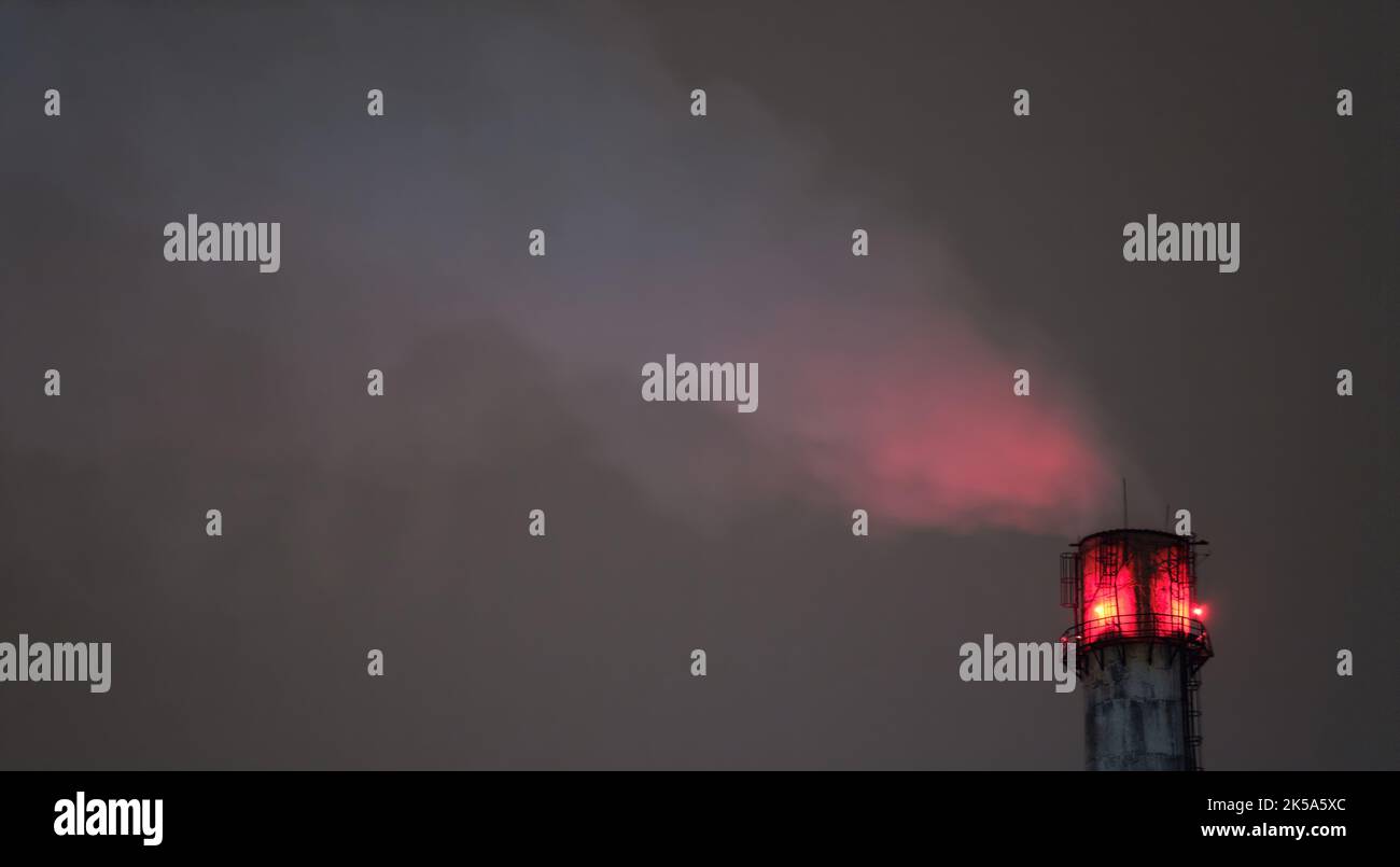 Pipe fumando facendo nuvole di notte. Contaminazione dell'aria da diossido. Inquinamento ambientale Foto Stock