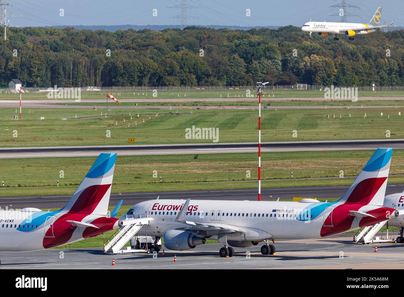 Aeroporto di Düsseldorf - aeromobile Eurowings in posizione di parcheggio durante lo sciopero dei piloti, aeromobile passeggeri Condor in avvicinamento per l'atterraggio Foto Stock