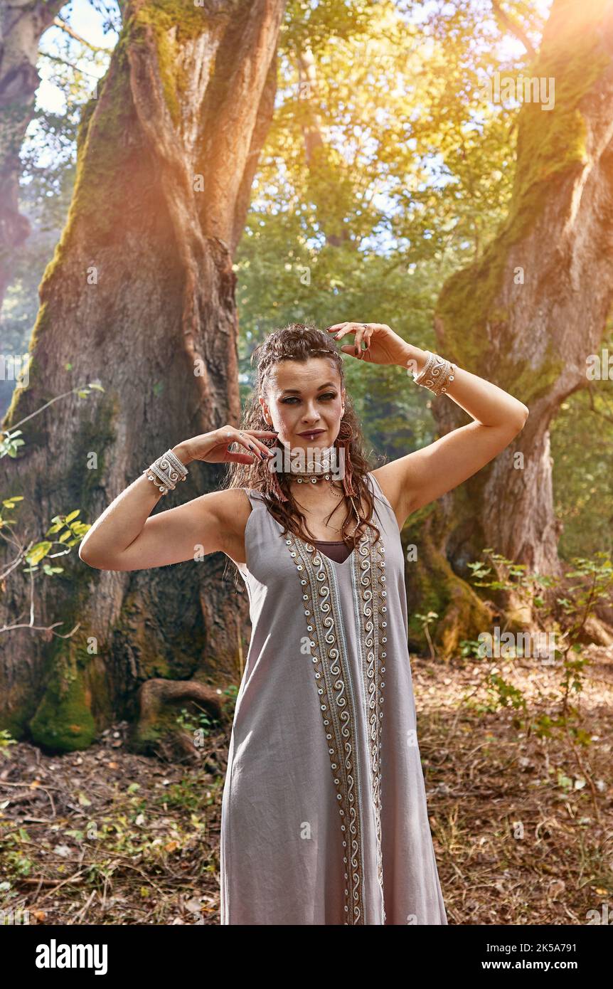 ragazza in un vestito cammina in una foresta misteriosa Foto Stock