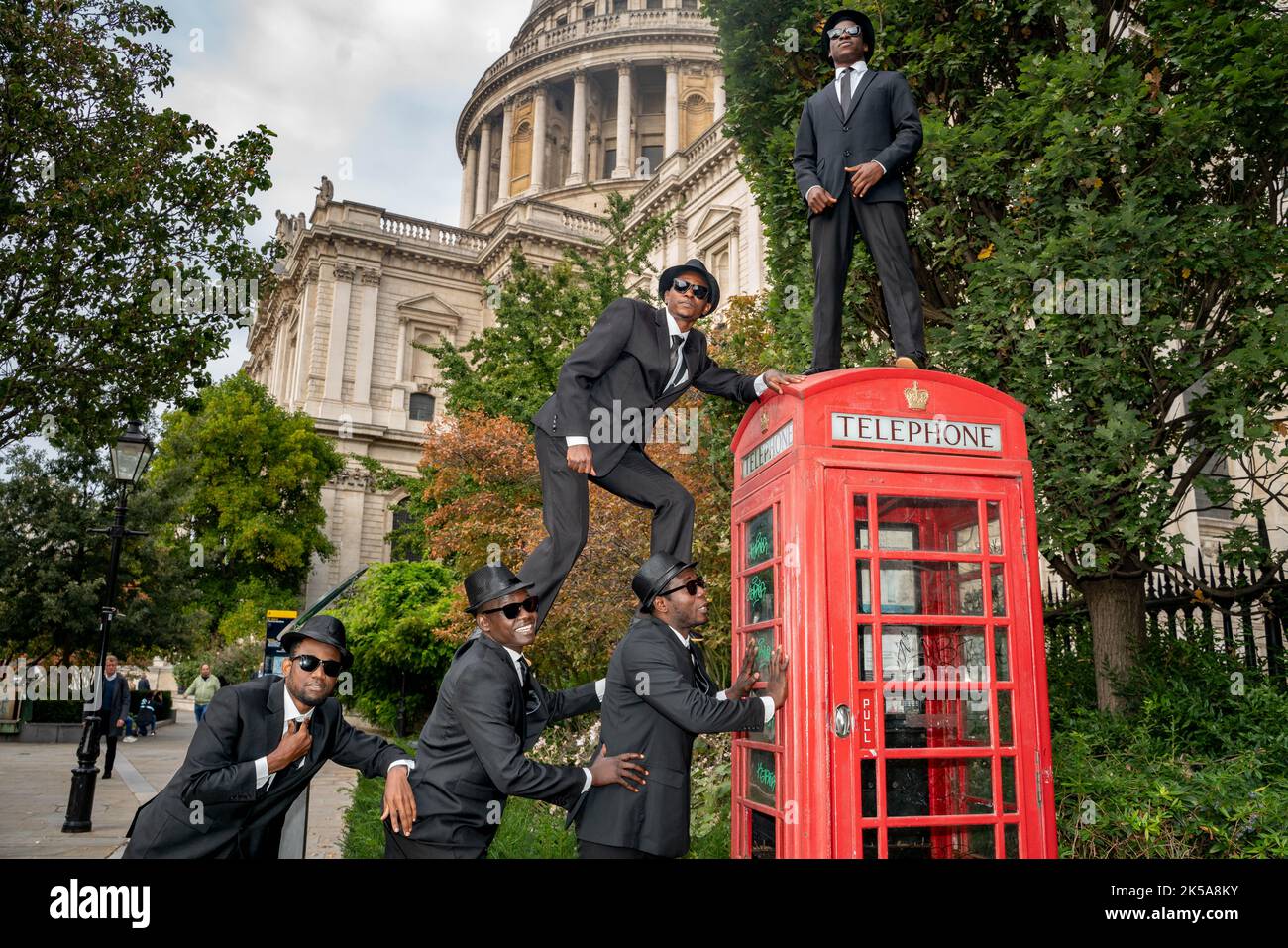 Bilal Musa Huka, Rashid Amini Kulembwa, Seif Mohamed Mlevi, Peter Mnyamosi Obunde e Mohamed Salim Mwakidudu AKA i fratelli del Blues Nero mostrano le loro abilità acrobatiche su e in una scatola telefonica rossa di londra contro la caduta posteriore della Cattedrale di San Paolo. I Black Blues Brothers sono una troupe di acrobati che si sono esibiti per Papa Francesco al Vaticano, alla Famiglia reale britannica e al Royal Variety Show. I Black Blues Brothers sono in tour nel Regno Unito con il loro spettacolo che è un tributo acrobatico al leggendario film di culto. I fratelli Black Blues utilizzarono un'iconica London Red Phone Box per una p Foto Stock